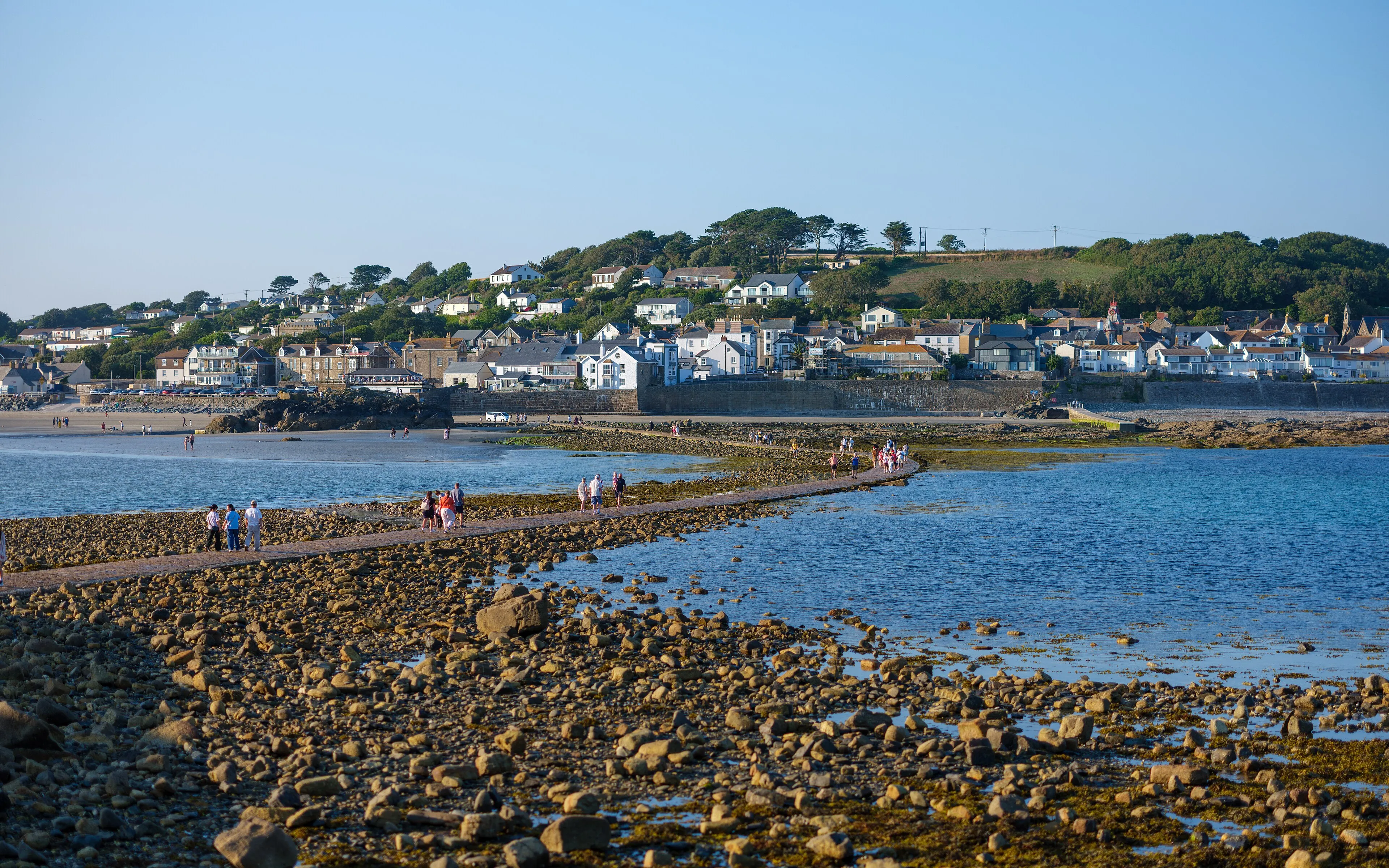 The causeway at low tide leading across the bay to Marazion, with houses on the hillside